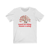 Image Description: White crew neck t-shirt. Orange and red maple leaves  on a brown tree trunk with a small black dog walking beside the tree trunk.  The www.DogsandTheirPaws.com url is under the tree.  The phrase, "Leaves are falling.  Autumn is calling." is below the image of the tree is in red.  