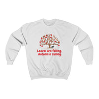 Image Description: White crew neck sweatshirt. There are orange and red maple leaves  on a brown tree trunk with a small black dog walking beside the tree trunk.  The www.DogsandTheirPaws.com url is under the tree.  The phrase, "Leaves are falling.  Autumn is calling." is below the image of the tree is in red.  