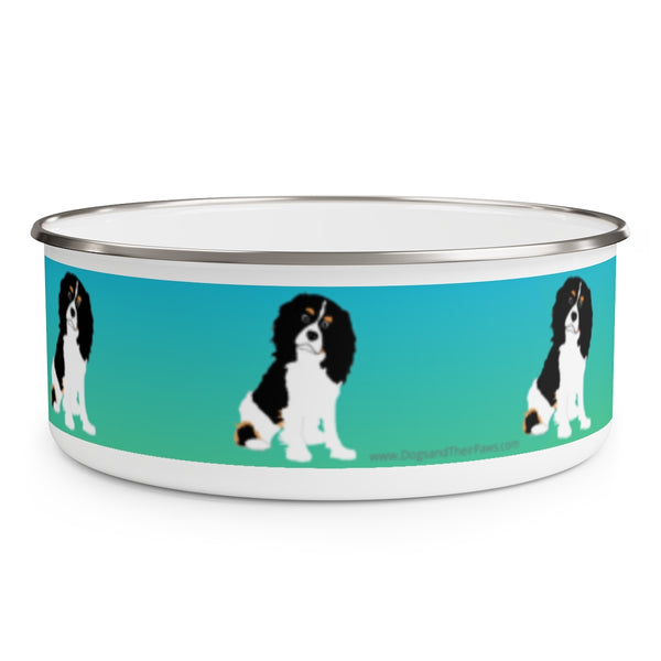 Cavalier King Charles Spaniel Enamel Bowl – Image description – White enamel bowl with a blue fading into green stripe with a Cavalier King Charles Spaniel sitting in the middle of the stripe. The dog has a black head and white body with his head slightly tilted. This dog is spaced out on the bowl and is visible in 3 places in this image. The top of the bowl has a silver rim. 