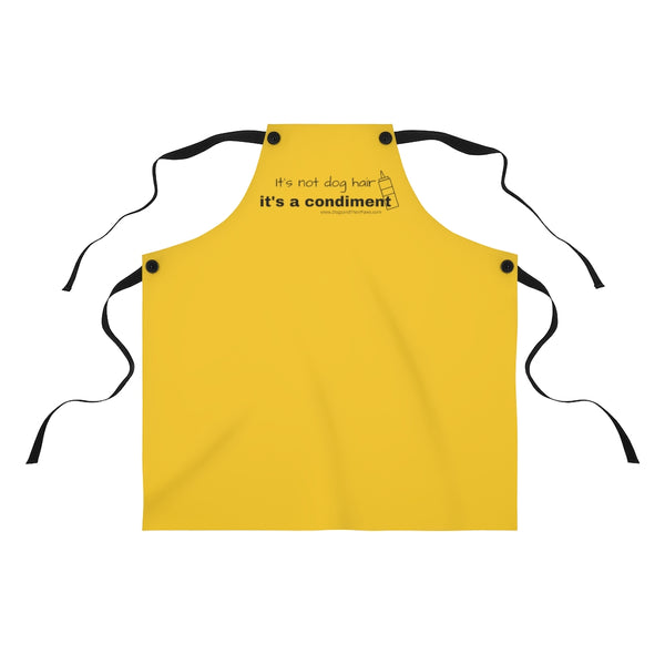 It's a Condiment Mustard Apron - Image description - mustard colored yellow apron with saying It's not dog hair it's a condiment with an outline of a condiment with 4 black ties attached to the red apron with black buttons on a white background. 