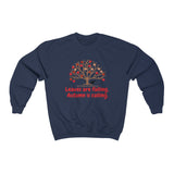 Image Description: Navy crew neck sweatshirt. There are orange and red maple leaves  on a brown tree trunk with a small black dog walking beside the tree trunk.  The www.DogsandTheirPaws.com url is under the tree.  The phrase, "Leaves are falling.  Autumn is calling." is below the image of the tree is in red.  