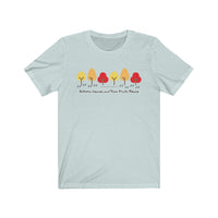 Image Description:  Light blue crew neck T-shirt with a row of 6 trees in yellow, orange and red with paw prints going into the middle with the dogs and their paws url with the words "Autumn Leave and Paw Prints Please" below the line of trees and paw prints.
