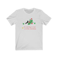 Tumbled Christmas Tree Unisex Jersey Tee - White t-shirt with a picture of a line Christmas tree on it's side and a black silhouette dachshund jumping on the tree with several red and green ornaments falling off the tree