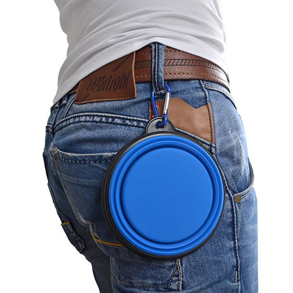 Folding Silicone Dog Bowl - Blue bowl folded flat, clipped to a belt loop on a model wearing a white t-shirt and pair of blue jeans. 